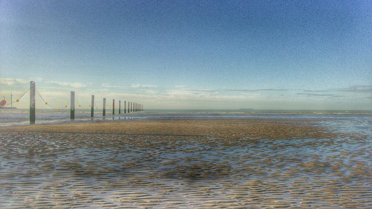 sea, water, tranquil scene, tranquility, horizon over water, scenics, beach, sky, beauty in nature, nature, pier, shore, blue, idyllic, sand, calm, built structure, bird, day, outdoors