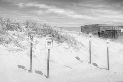 Disabled access signs on snowy hill against sky