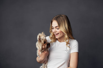 Young woman with dog against black background