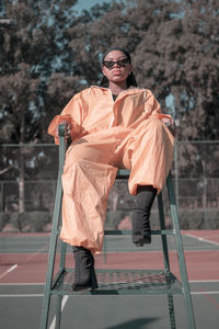 Full length of girl sitting on chair in court