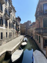 Canal amidst buildings in city against clear sky