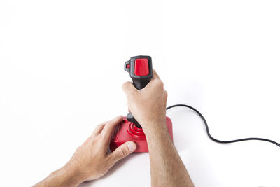 Close-up of hand holding mobile phone over white background