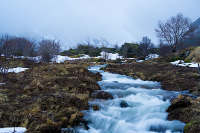 Scenic view of river stream against sky during winter