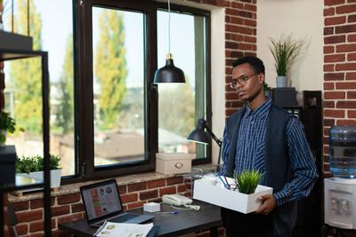 Side view of young woman using digital tablet in office