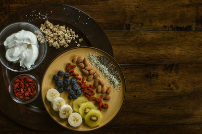 Healthy and delicious plate of fruit, nuts and seeds with yogurt and gogi berries