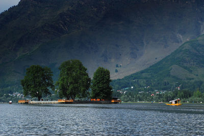 Scenic view of river by trees against mountains