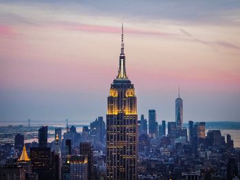 Modern buildings in city against sky during sunset