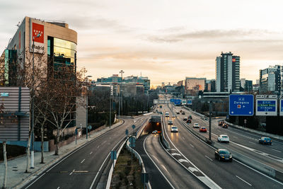 Vehicles on road in city against sky
