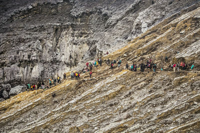 People on cliff against mountains