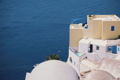 High angle view of building by sea against blue sky