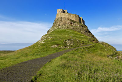 Stone wall of historic building against sky