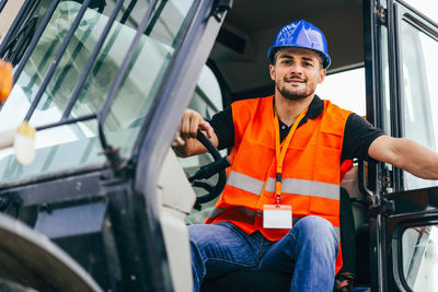 Portrait of construction worker driving crane