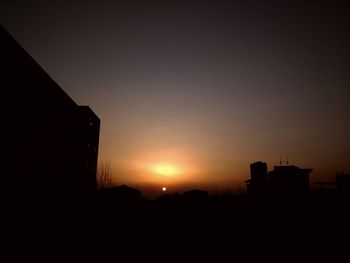 Silhouette buildings against sky during sunset