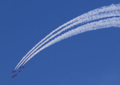 Low angle view of airplane flying against clear blue sky