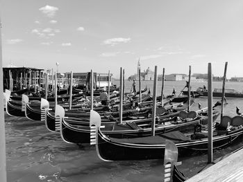 Boats moored in canal against sky