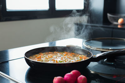 Steaming vegetable stew in a pan at the modern kitchen