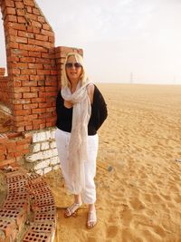 Portrait of young woman wearing sunglasses standing on land