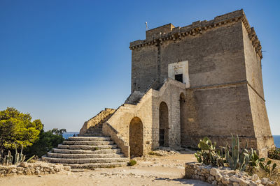 Low angle view of historical building against clear blue sky