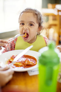 Portrait of girl eating food at restaurant