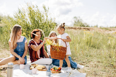 A beautiful baby gives flowers collected during a picnic to her grandmother