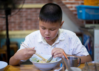 Midsection of boy holding ice cream in bowl