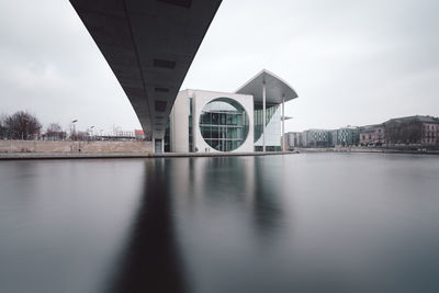 Bridge over river against buildings in city