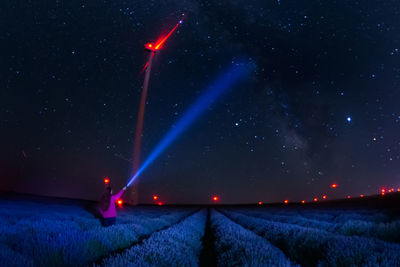 Scenic view of illuminated field against sky at night