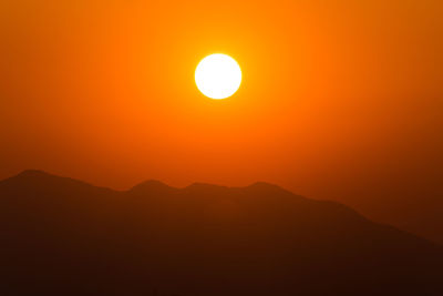 Scenic view of silhouette mountains against romantic sky at sunset