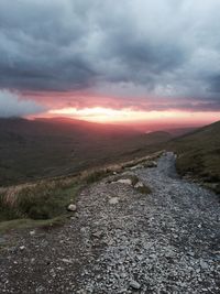 Surface level of road against sky during sunset