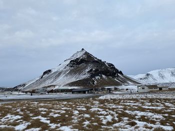 Snow covered land and mountains against sky