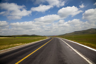 Empty road along countryside landscape