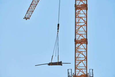 Low angle view of crane against clear sky