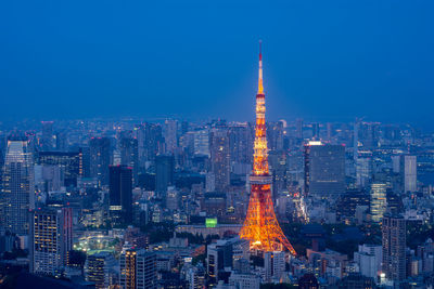 Illuminated buildings in city against sky