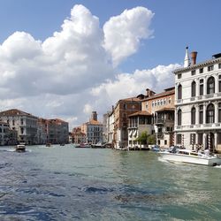 Buildings in city against cloudy sky