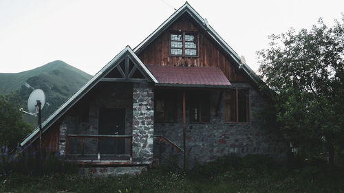 Exterior of old house on field against clear sky