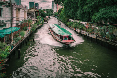 Boat sailing on river in city