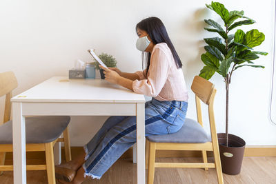 Woman sitting on table at home