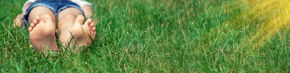 Low section of woman sitting on grassy field