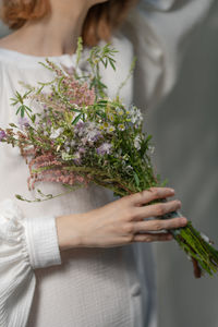 Midsection of woman holding flower bouquet