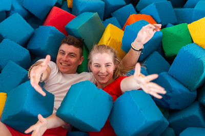 High angle portrait of couple lying amidst cubes