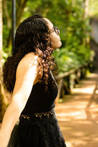 Midsection of woman standing by tree against plants