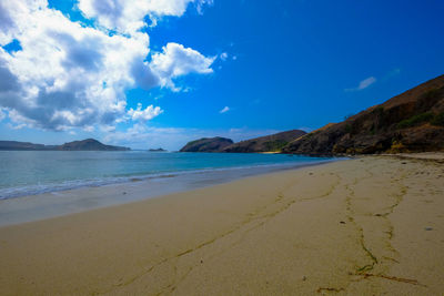 Scenic view of beach against blue sky