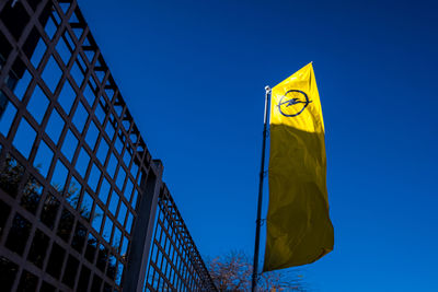 Low angle view of flag against blue sky