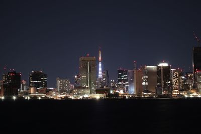 Illuminated buildings in city against sky at night