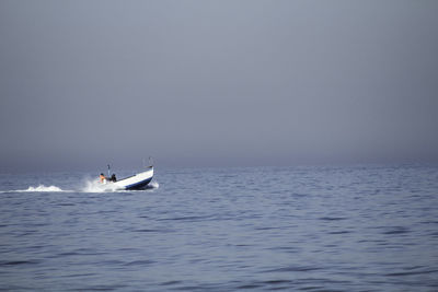 Speedboat moving on sea against sky