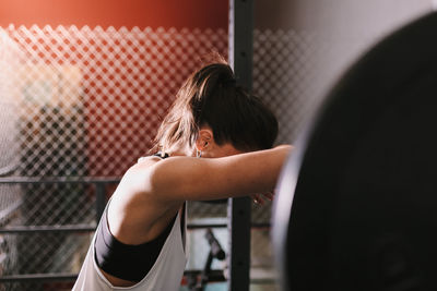 Female athlete exercising with barbell in gym