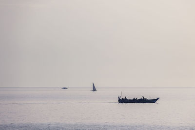 Sailboat sailing on sea against clear sky