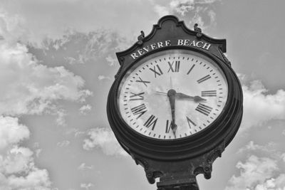 Low angle view of clock against sky