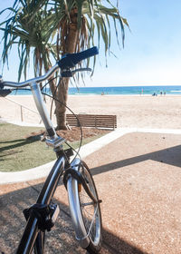 Bicycle on beach against sky