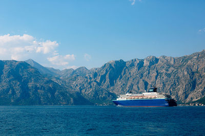 Scenic view of sea by mountains against sky